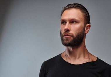 Sakal ve saç modeli tarafına seyir siyah t-shirt ile yakışıklı bir erkek.
