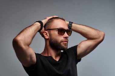 Yakın çekim portre yakışıklı bir moda erkek güneş gözlüğü ve siyah t-shirt.