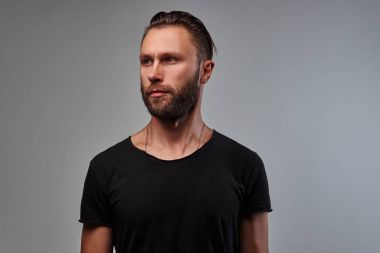Sakal ve saç modeli tarafına seyir siyah t-shirt ile yakışıklı bir erkek.