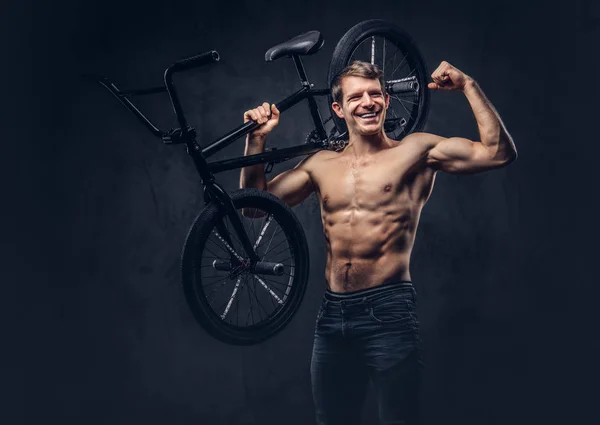 ハンサムな Bmx を持って人を肩に乗せて自転車上半身裸の男の笑みを浮かべてします 暗い背景に分離 — ストック写真