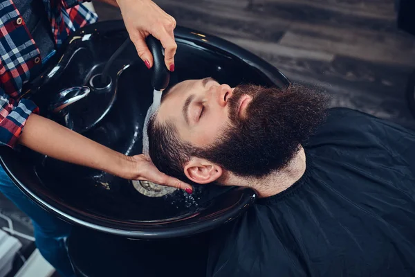 专业美发师清洗客户头在一个黑色的时髦洗脸盆 理发店 — 图库照片