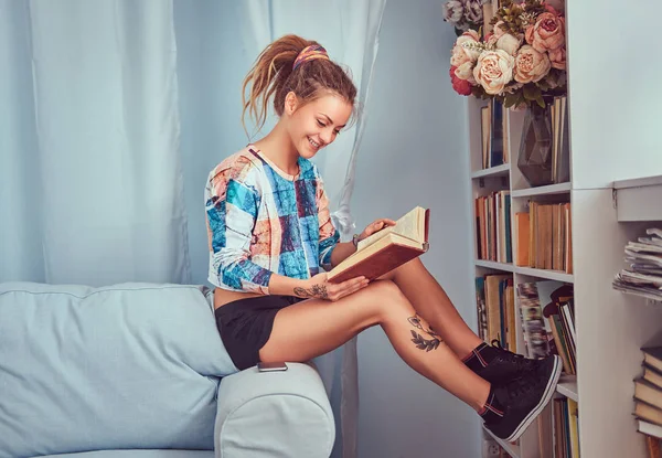 Giovane Ragazza Tatuata Leggere Libro Seduto Divano Casa — Foto Stock