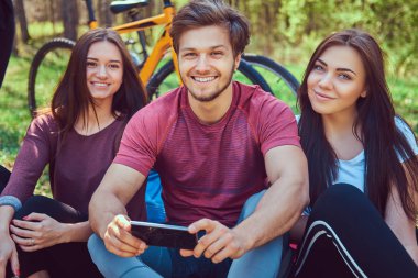 Arkadaş grubu zemin relax ve konuşma birlikte parkta bisikleti sonra oturuyor. Dostluk kavramı.