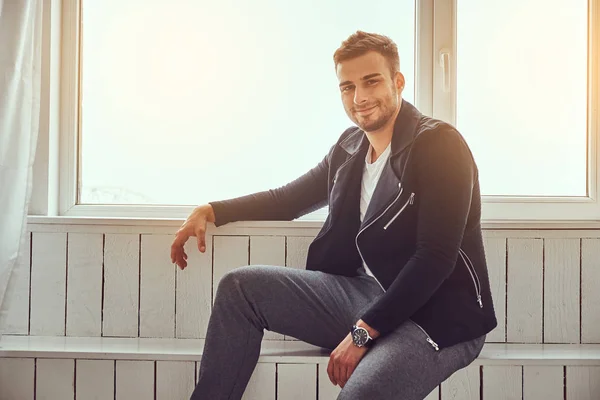 Een Ontspannen Knappe Jonge Kerel Stijlvolle Kleding Horloge Zittend Vensterbank — Stockfoto