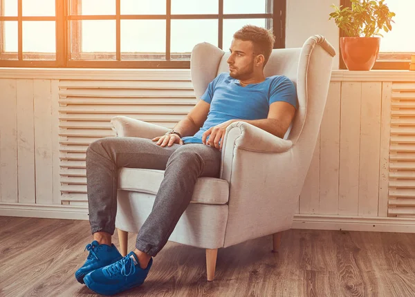 Jovem Bonito Uma Camiseta Azul Tênis Relaxante Enquanto Sentado Uma — Fotografia de Stock