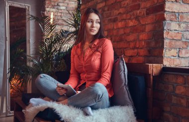 Bir tablet ile rahat kıyafetler büyüleyici bir esmer 