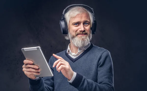 Portrett Kjekk Avgangselev Som Bruker Nettbrett Med Hodetelefoner Studio Mørk – stockfoto