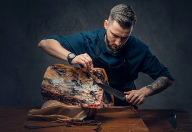 Profesyonel kasap bir masada çiğ füme et kesme 