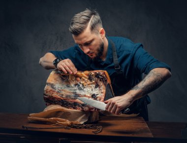 Profesyonel kasap bir masada çiğ füme et kesme