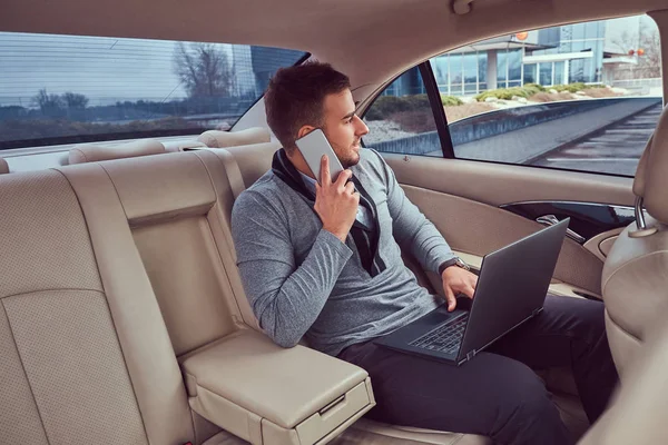 Homem Negócios Bonito Roupas Elegantes Trabalhando Seu Laptop Falando Telefone — Fotografia de Stock