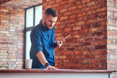 Onun kol ayakta çatı iç ile bir odada bir dövme ile mutlu yakışıklı erkek.