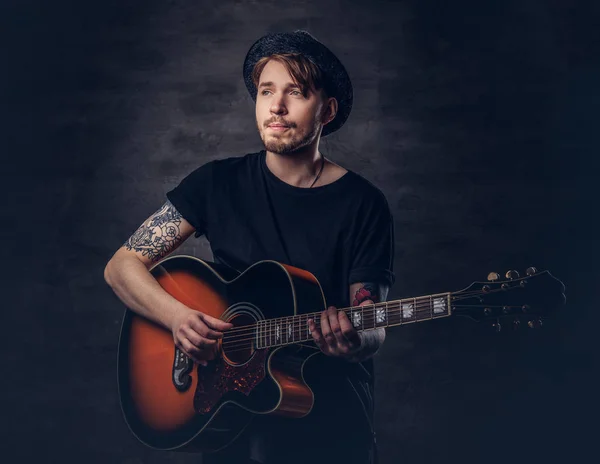 Attractive Tattooed Guitarist Hat Playing Acoustic Guitar Isolated Dark Background — Stock Photo, Image