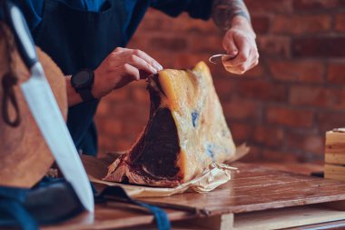 Profesyonel kasap bir masada çiğ füme et kesme