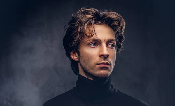 Portrait of a charismatic sensual male in black sweater. Creative personality.