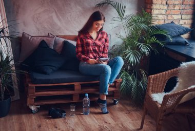 Pazen tişört ve kot bir kanepede oturan sevimli esmer