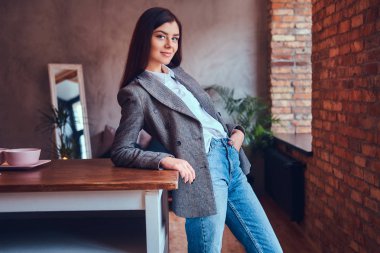 Bir tabloda bir odada yaslanmış bir seksi esmer portresi