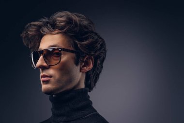 Şık saç siyah kazak ve güneş gözlüğü ile şehvetli bir maço erkek portresi stüdyo.