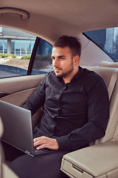 Przystojny Biznesmen Czarną Koszulę Pracę Laptopem Samochodzie — Zdjęcie stockowe