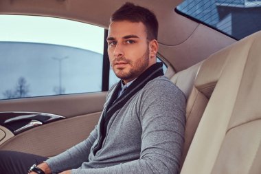 Şık giyim arabada otururken yakışıklı bir moda erkek.