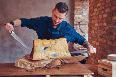 Profesyonel kasap bir masada çiğ füme et kesme