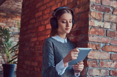 Bir mutlu genç ince şehvetli kız tablet ile gri elbiseli