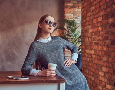 Genç bir ince şehvetli kız gri elbise ve güneş gözlüğü 