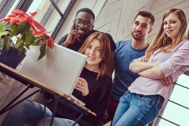 Genç çok ırklı öğrenci ile bir dizüstü bilgisayar çalışma grubu.