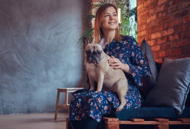 Stüdyo portre çekici bir mutlu sarışın bir çatı katı iç ile bir odada.