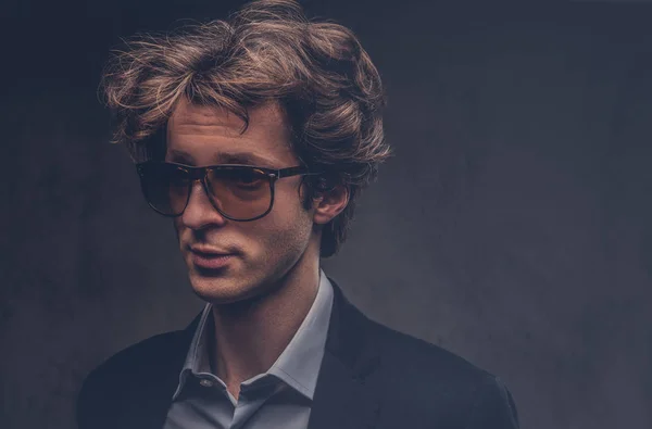 Studio portrait of a charismatic sensual macho with stylish hair and sunglasses