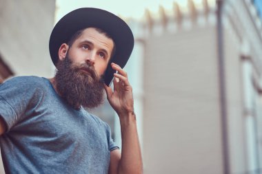 Yakışıklı hipster rahat kıyafetler giymiş şık sakallı erkek ve telefonda konuşan.