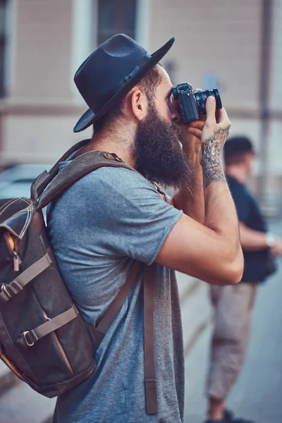 写真カメラを使用してカジュアルな服に身を包んだスタイリッシュなひげと彼の腕のタトゥーとハンサムな流行に敏感な男性 — ストック写真