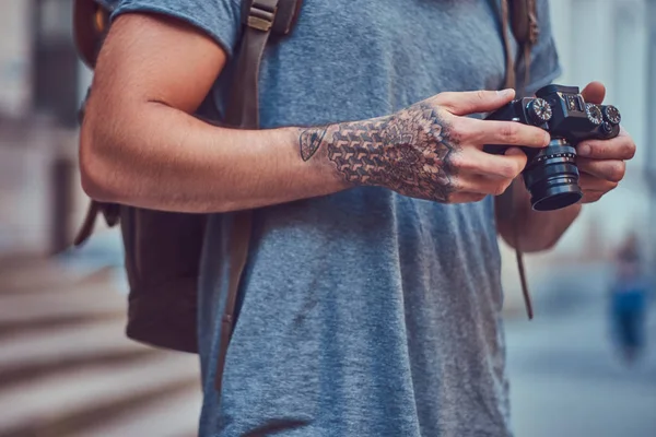写真カメラを使用してカジュアルな服に身を包んだハンサムな流行に敏感な彼の腕のタトゥーの男性 — ストック写真