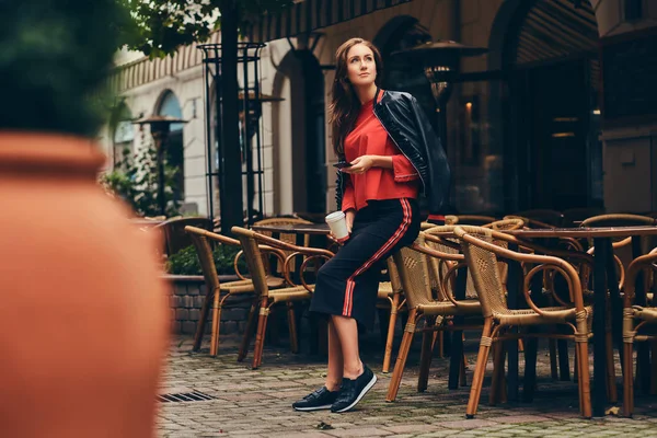 Modne brunetka w Stylowa odzież ma zabawy w pobliżu kawiarni — Zdjęcie stockowe