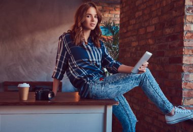 Sevimli genç kız fotoğrafçı bir tablet ile çalışma masaya oturur