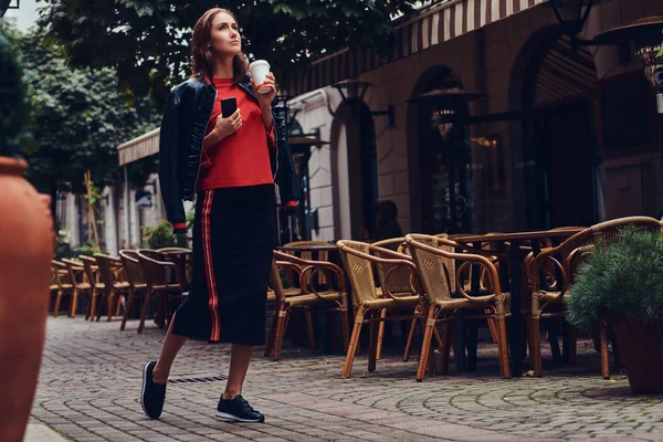 Módní brunetka v stylové oblečení má zábavu nedaleko kavárny — Stock fotografie