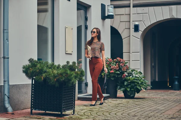 Hermosa morena de moda en una ropa de moda y gafas de sol — Foto de Stock