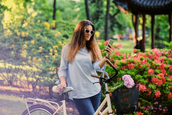Портрет привлекательной брюнетки с городским велосипедом рядом с традицией — стоковое фото