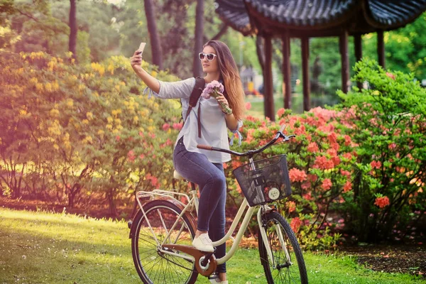 Retrato de atractiva morena con bicicleta de ciudad cerca de la tradición — Foto de Stock