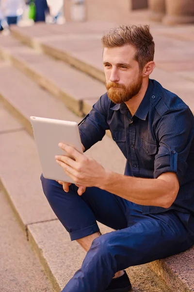 Handsome bearded male in casual clothes with the tablet computer — Stock Photo, Image