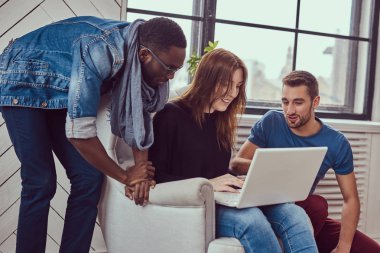 Çok ırklı öğrenci ile bir dizüstü bilgisayar çalışma grubu.