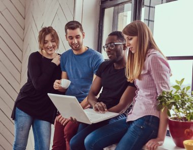 Çok ırklı öğrenci ile bir dizüstü bilgisayar çalışma grubu.