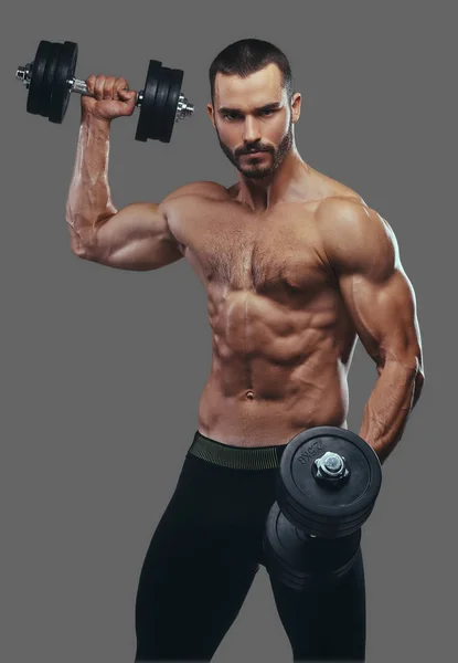 Dumbell ile çalışma dışarı bir kas adam. Üzerinde gri bir ba izole — Stok fotoğraf