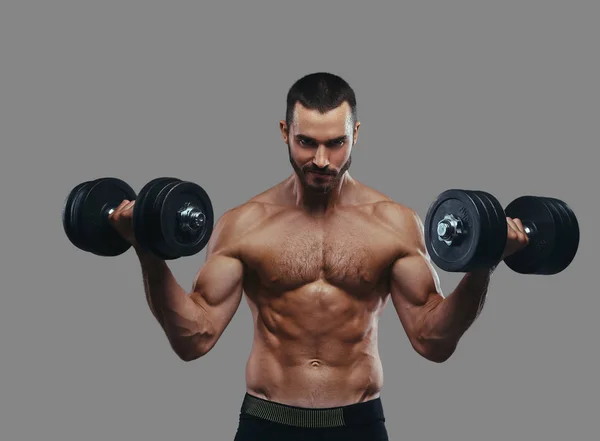 Ein muskulöser Typ, der mit Hanteln trainiert. isoliert auf einem grauen ba — Stockfoto