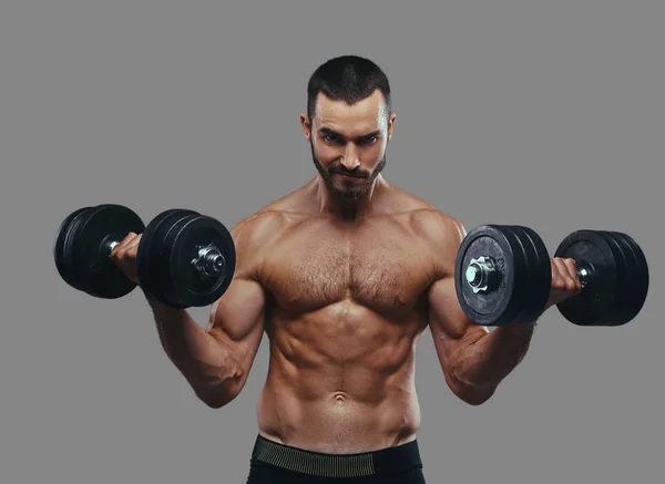 Un tipo musculoso haciendo ejercicio con pesas. Aislado en una ba gris —  Fotos de Stock