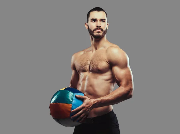 Ein brutaler athletischer bärtiger Mann ohne Hemd posiert mit einem Medaillenball o — Stockfoto