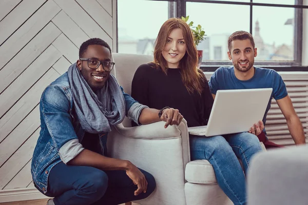 Gruppe multiethnischer Studenten, die mit einem Laptop arbeiten. — Stockfoto