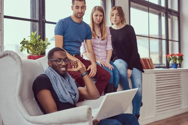 Groupe d'étudiants multiraciaux travaillant avec un ordinateur portable . — Photo