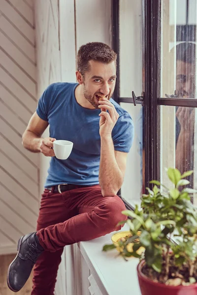 Νεαρός φοιτητής Καυκάσιος πίνει καφέ το πρωί που κάθεται σε ένα windo — Φωτογραφία Αρχείου