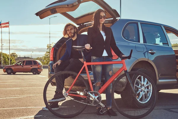 Atractiva Pareja Elegante Con Una Bicicleta Cerca Del Coche Con — Foto de Stock