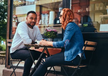 İçme kahve, kahve dükkan yakın oturan çift. Açık havada bir tarihte.